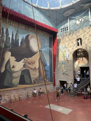 The main hall of the Dalí Theatre-Museum in Figueres, with a large mural behind the stage